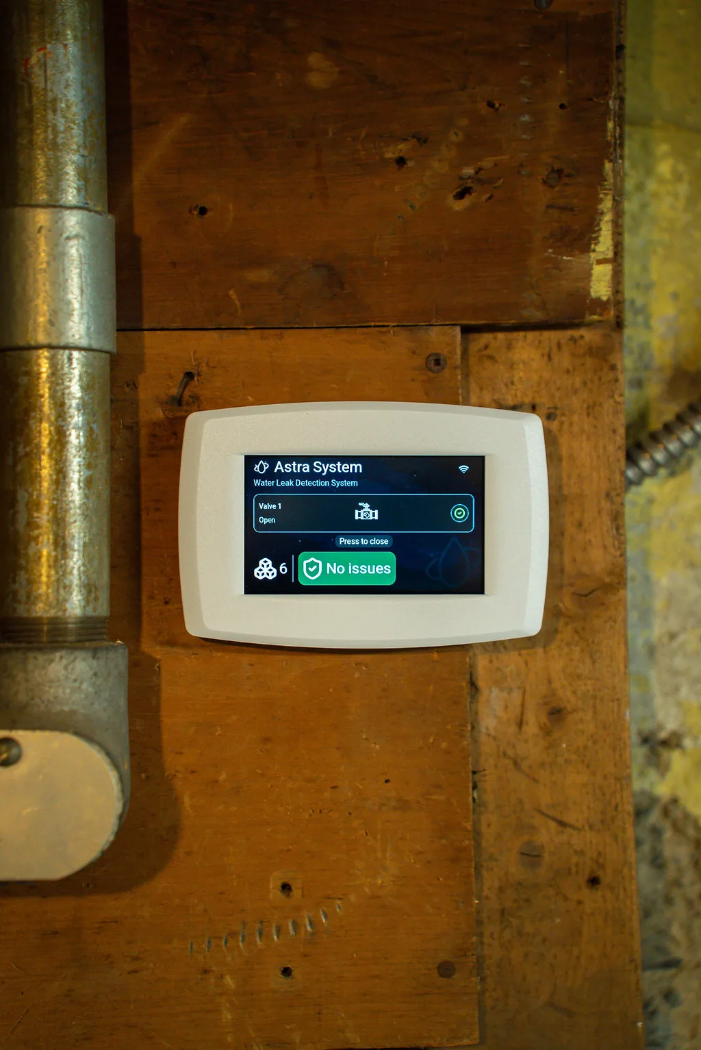 Wall-mounted Astra Panel beside mechanical-room piping
